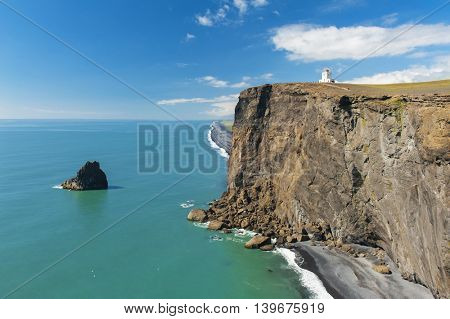 Small lighthouse on the cliff at the cape Dyrholaey, the most southern point of Iceland. 