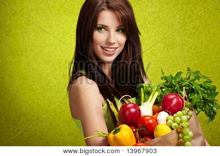 Donna con una borsa piena di frutta e verdura nutriente