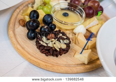 Cheese plate with variety of appetizers on table