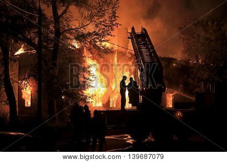 two silhouettes on fire truck on housefire background