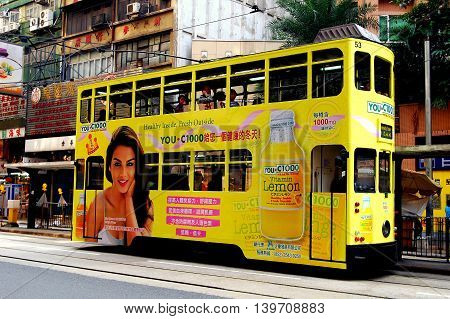 Hong Kong China - December 16 2007: A double-decker tram covered in advertising runs along its tracks on Des Voeux Road at Central *