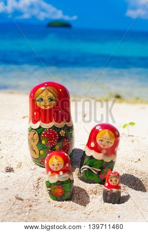 Photo Rows Puzzle Russian Dolls Matrioshka Family Souvenir Untouched Tropical Beach in Bali Island. Vertical Picture. Blurred Background. Closeup