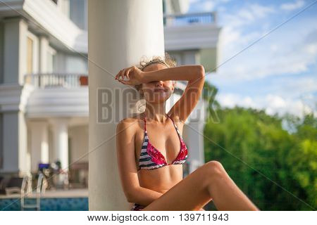 Photo Young Pretty girl Relaxing on Swimming Pool Terrace with Beautiful View. Smiling Woman Spending Chill Time Outdoor Summer. Caribbean Ocean Vacations. Horizontal, blurred background