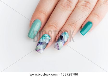 Closeup of woman nails with creative purple and green manicure. Fluorinit print. Copy space.