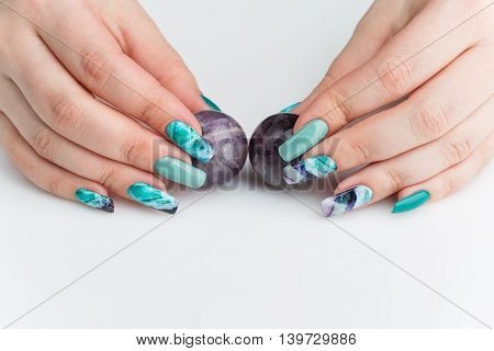 Closeup of woman nails with creative purple and green manicure. Fluorinit print. Copy space.