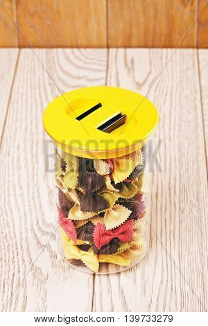 raw bow-knot pasta of different color in plastic container