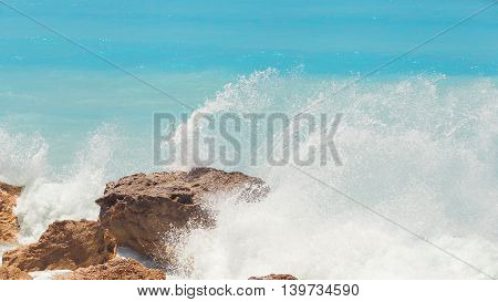 Rocky beach on Lefkada coast. Detail of breaking waves on beach, Lefkada, Greece waves crashing among rocks