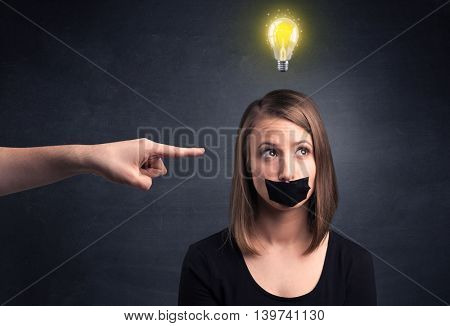 Caucasian hand pointing at female employee with a lightbulb above her head