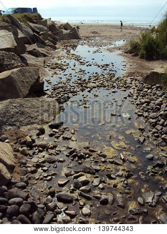 River leading to beach seascape photographed at Widemouth Bay in Cornwall