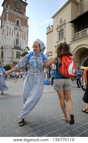 CRACOW POLAND - JULY 24 2016: Pilgrims of World Youth Day sing and dance on the Main Square in Cracow. Poland