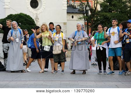 CRACOW POLAND - JULY 24 2016: Pilgrims of World Youth Day sing and dance on the Main Square in Cracow. Poland