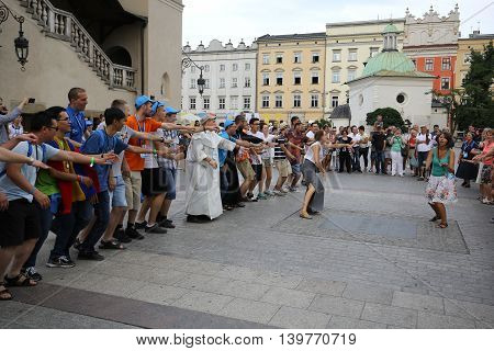 CRACOW POLAND - JULY 24 2016: Pilgrims of World Youth Day sing and dance on the Main Square in Cracow. Poland
