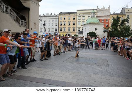 CRACOW POLAND - JULY 24 2016: Pilgrims of World Youth Day sing and dance on the Main Square in Cracow. Poland