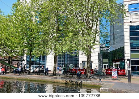 BIRMINGHAM, UNITED KINGDOM - JUNE 6, 2016 - View towards the rear of the ICC with people relaxing in the foreground at Brindleyplace Birmingham England UK Western Europe, June 6, 2016.