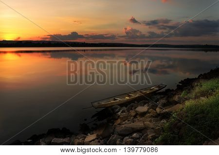 sunset at the river and fishing boat on the shore