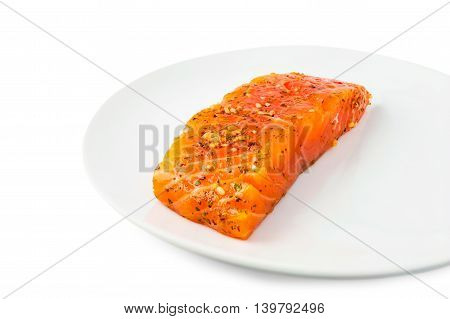 fresh marinated slice of salmon on plate isolated on white background