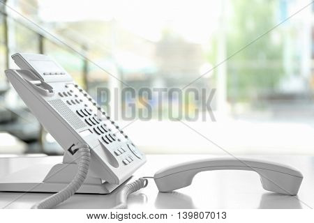 Modern office IP telephone set on light blurred background