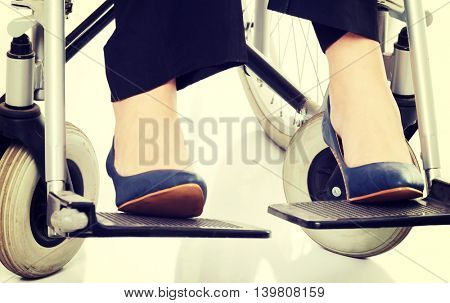 Female's legs and shoues on wheelchair.