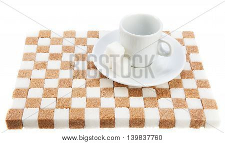 empty coffee cup on a saucer with three cubes of sugar on a stand of brown and white sugar. Isolated on white.