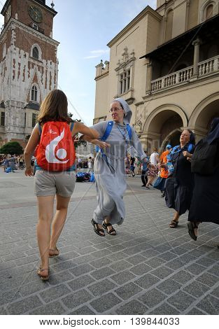 CRACOW POLAND - JULY 24 2016: Pilgrims of World Youth Day sing and dance on the Main Square in Cracow. Poland