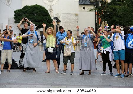 CRACOW POLAND - JULY 24 2016: Pilgrims of World Youth Day sing and dance on the Main Square in Cracow. Poland