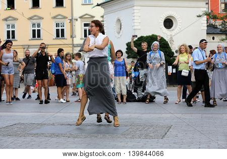 CRACOW POLAND - JULY 24 2016: Pilgrims of World Youth Day sing and dance on the Main Square in Cracow. Poland