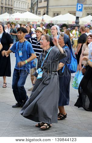 CRACOW POLAND - JULY 24 2016: Pilgrims of World Youth Day sing and dance on the Main Square in Cracow. Poland