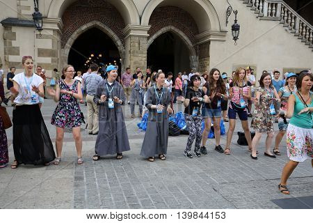 CRACOW POLAND - JULY 24 2016: Pilgrims of World Youth Day sing and dance on the Main Square in Cracow. Poland