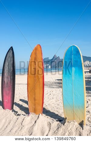 Surfboards standing upright in bright sun on the Ipanema beach Rio de Janeiro Brazil