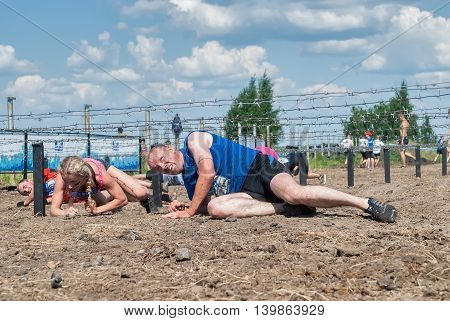 Tyumen, Russia - July 9, 2016: Steel Character extrim race on Voronino Hill. Army Test. People jumping, crawling, passing under a barbed wires or climbing obstacles during extreme obstacle race