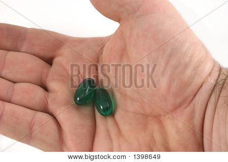 Green Gelcaps In A Mans Hand