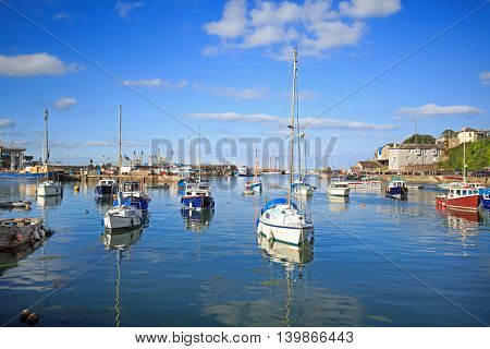 Seascape in Brixham Harbour with a bright blue sky and calm sea