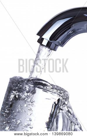 Water tap is pouring overflowing glass isolated on white background