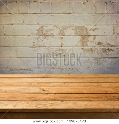 Empty wooden deck table over grunge stone wall