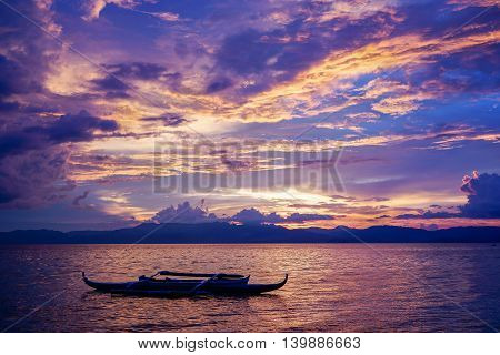 Amazing colorfull sunset at the sea with philippine boat in Moalboal
