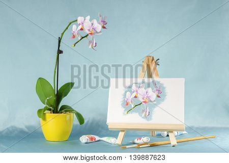 Collage with orchid flower, easel and watercolors. Digital picture on an easel stylized watercolor.