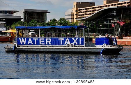 Baltimore Maryland - July 22 2013: A city water taxi pulls into the Inner Harbor dock