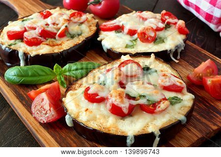 Healthy Eggplant Mini Pizzas With Melted Mozzarella, Tomatoes And Basil, Close Up On A Paddle Board