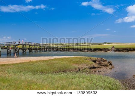 SANDWICH, MASSACHUSETTS - JULY 14, 2016: Tourists walk across the Sandwich Boardwalk at Mill Creek MA. Sandwich first settled in 1637 is the oldest town on Cape Cod.