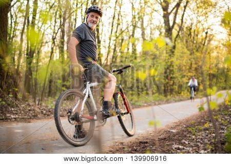 Senior man on his mountain bike outdoors (shallow DOF; color toned image)