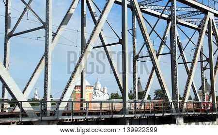 Railway metal bridge perspective view. Russian monastery on backdrop
