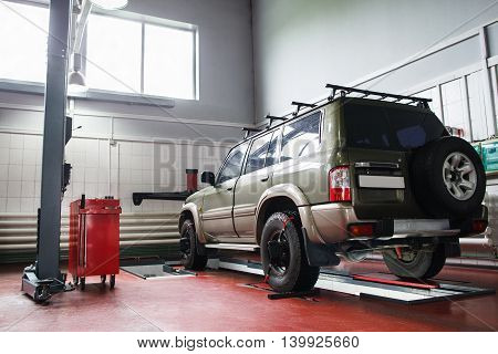 SUV wheel alignment at professional service. Car ready for maintenance in modern garage