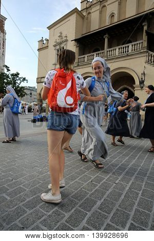 CRACOW POLAND - JULY 24 2016: Pilgrims of World Youth Day sing and dance on the Main Square in Cracow. Poland