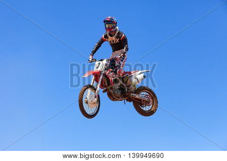 Wingate, Israel - July 23, 2016: Motocross rider and bike clearing a tabletop jump during the final heat of the race.