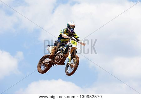 Wingate, Israel - July 23, 2016: Motocross rider and bike clearing a tabletop jump during the final heat of the race.