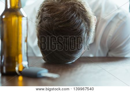 Depressed man with head down on a bar counter at restaurant
