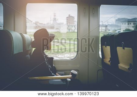 Enjoying travel. Young pretty woman traveling by the japan classic train sitting near the window. vintage filter.
