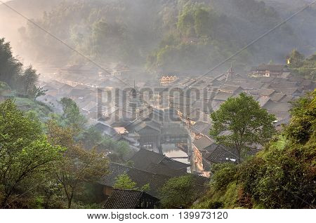 Wooden house dong ethnic minority village in a mountainous southwestern China misty dawn spring time, Zhaoxing Dong Village Guizhou Province China.