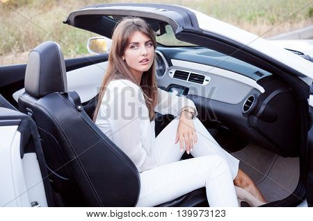 business Lady sits in white cabriolet, travel
