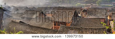 Liping County Qiandongnan Miao and Dong Autonomous Prefecture Tile roofs of wooden houses in a large ancient village panoramic picture, Zhaoxing Village Guizhou Province China.